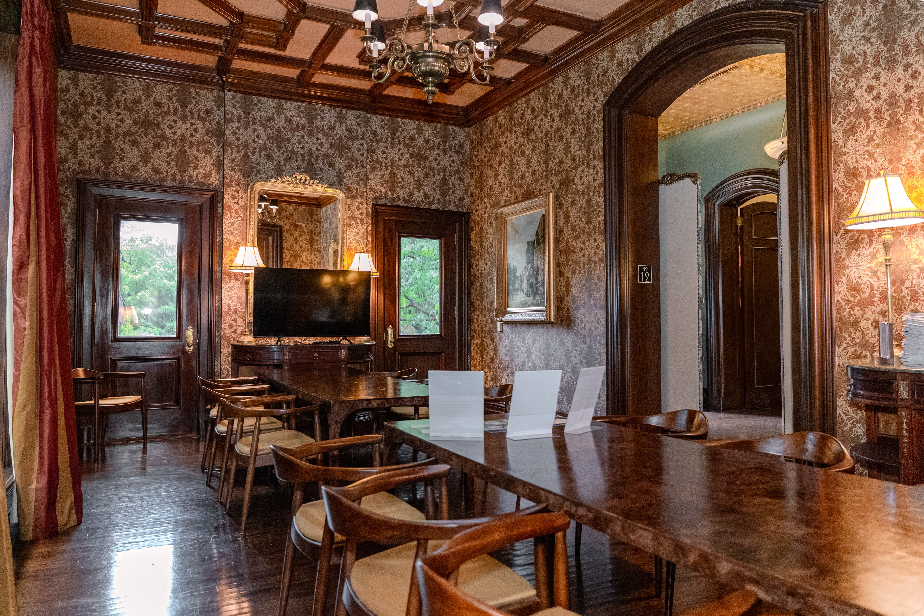 A wood-panelled parlour with the original carved mantel and coffered ceiling