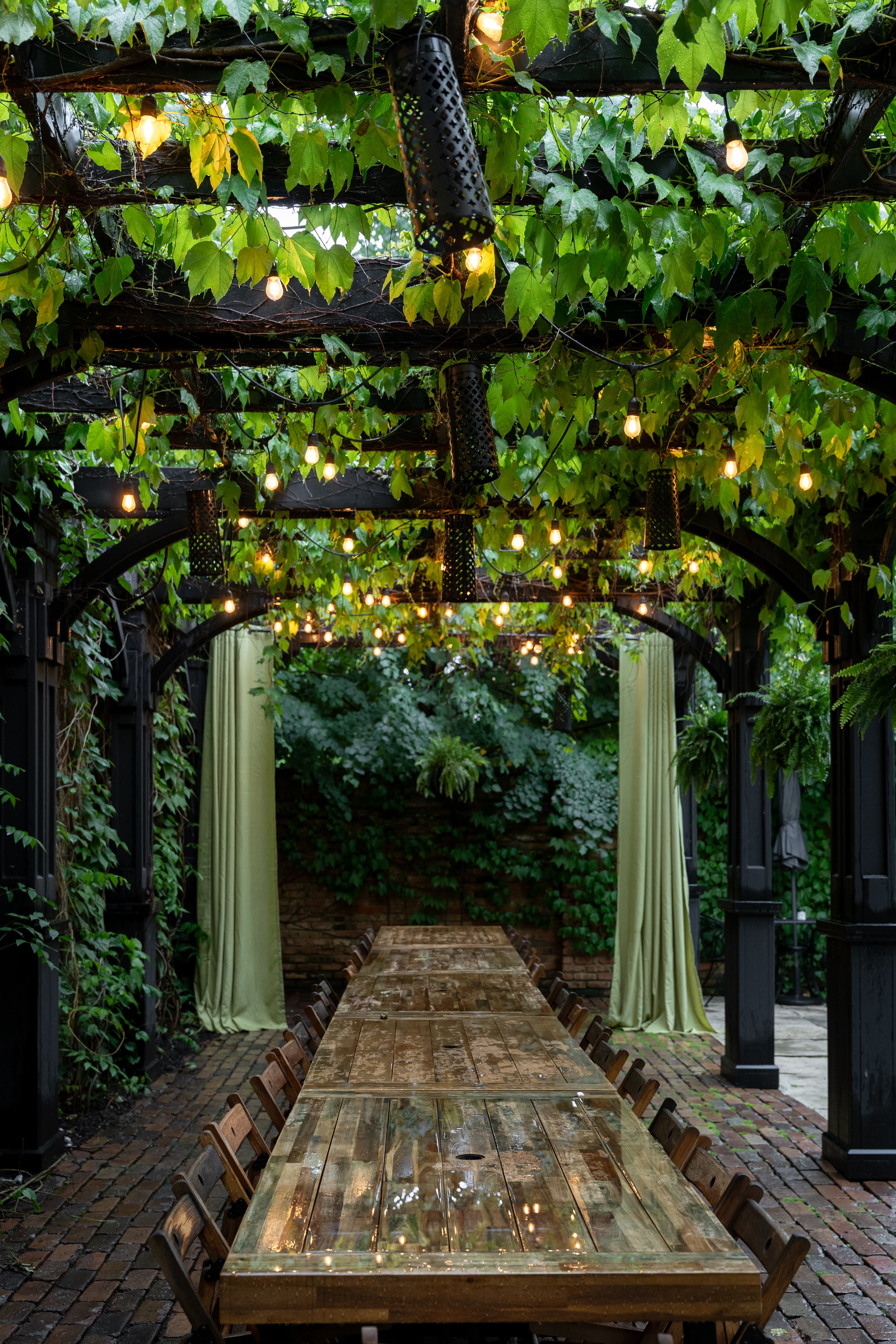 The long communal table under the garden pergola set for a leisurely gathering